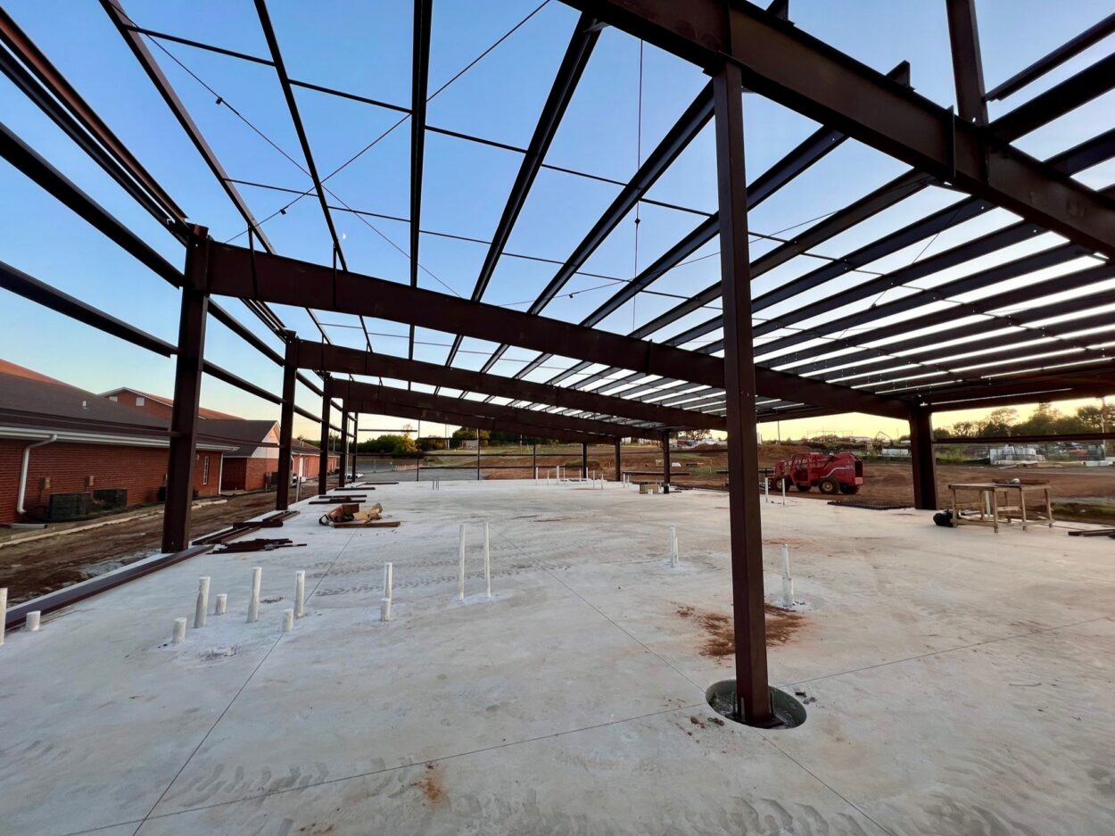 Steel frame under construction on a church building project at sunset